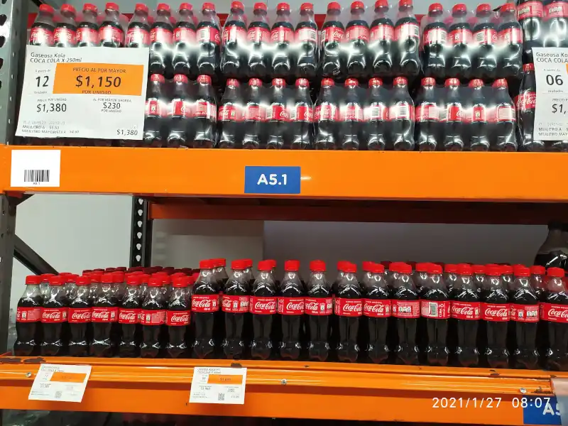 Etiqueta de ubicación con código de barras pegada en estantería.